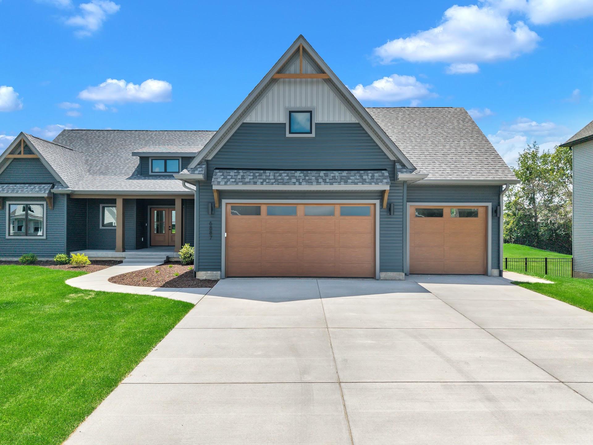 Wood-look garage doors installed on a newly built craftsman home
