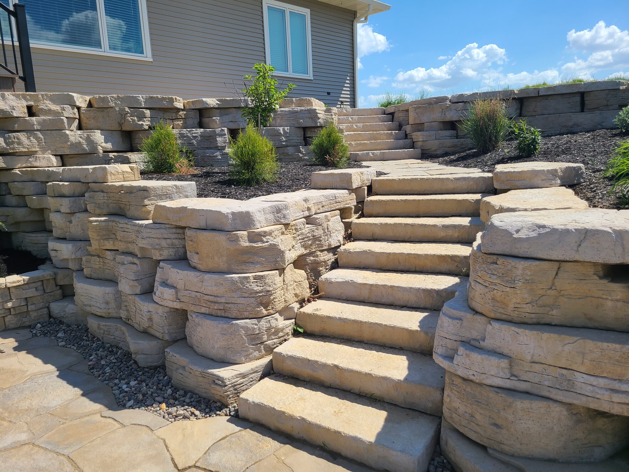 Natural stone retaining wall and steps installed by a hardscaping contractor